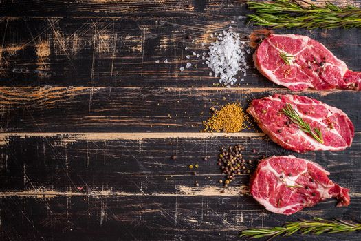 Raw juicy meat steak on dark wooden background