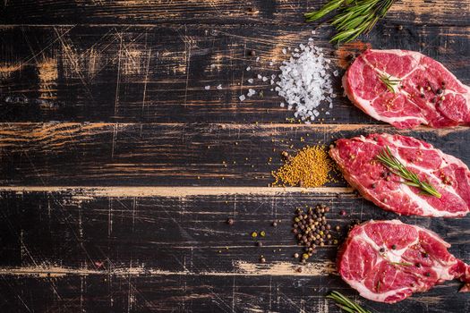 Raw juicy meat steak on dark wooden background