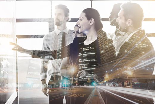 Multiple exposure shot of a group of colleagues superimposed over a city background.