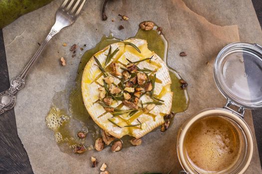 Delicious beautiful baked camembert with honey, walnuts, herbs and pears