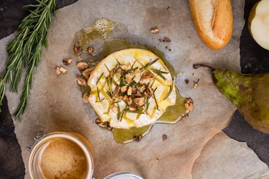 Delicious beautiful baked camembert with honey, walnuts, herbs and pears