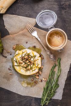 Delicious beautiful baked camembert with honey, walnuts, herbs and pears