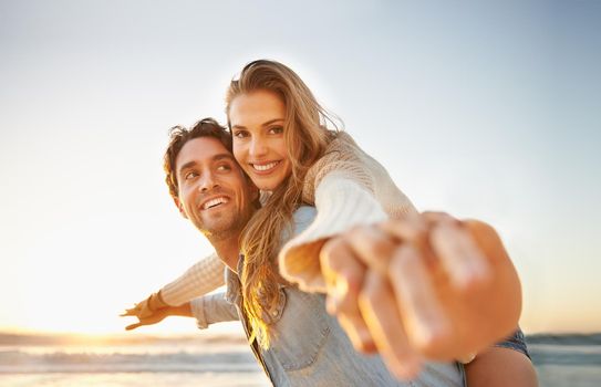 A blissful young couple celebrating their love on the seashore together.