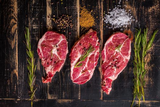 Raw juicy meat steak on dark wooden background