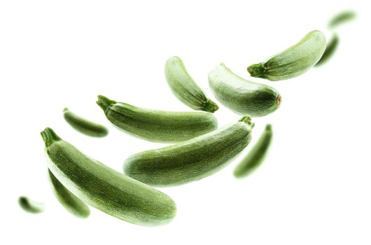 Green zucchini levitate on a white background.