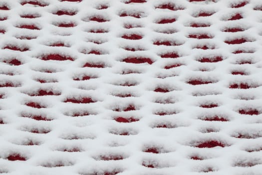 White and red background, snow on the hammock, snow pattern and texture