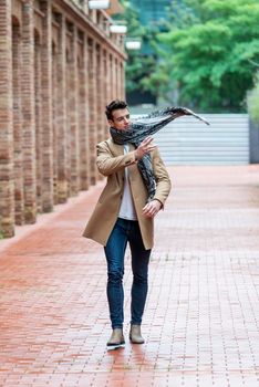 Handsome young man wearing winter clothes walking on the city. Street photo concept.