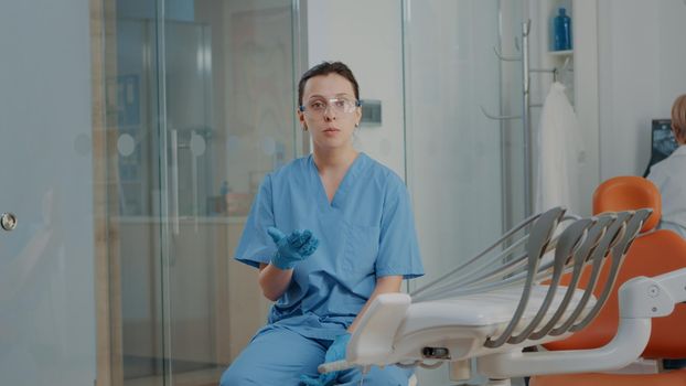 POV of woman nurse meeting on video call with patient, doing oral care consultation in dentistry cabinet. Stomatology assistant attending online videoconference for remote conversation.