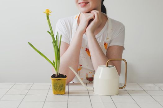 lovely housewife woman in apron with flower in pot. Gardening, holidays, Spring and Easter concept