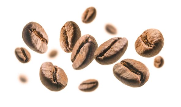 Coffee beans levitate on a white background.