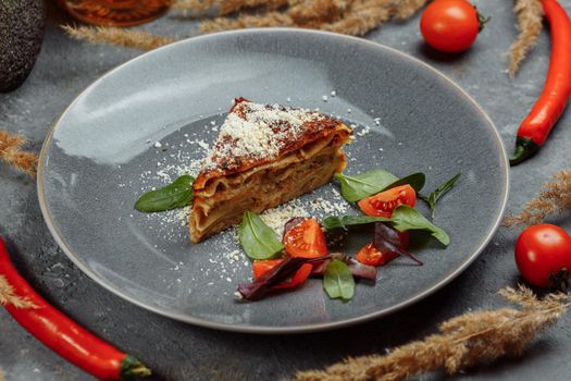 Homemade delicious Meat lasagna with basil leaf on the top. Close up. Recipe, menu. Italian cuisine. Side view.