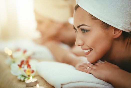 Two cute young women are enjoying during a skin care treatment at a spa. 