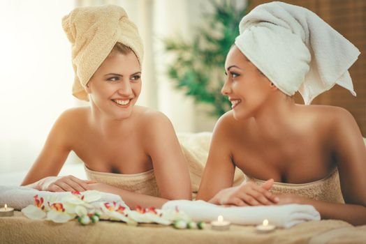 Two cute young women are enjoying during a skin care treatment at a spa. 