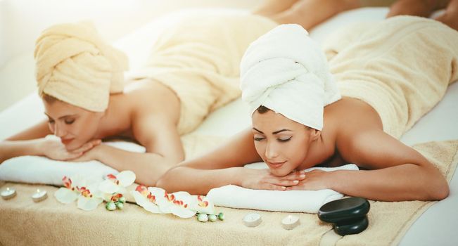 Two cute young women are enjoying during a skin care treatment at a spa. 