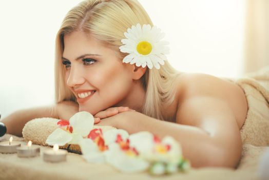 Cute young woman is enjoying during a skin care treatment at a spa. 