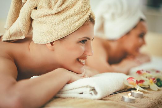 Two cute young women are enjoying during a skin care treatment at a spa. 