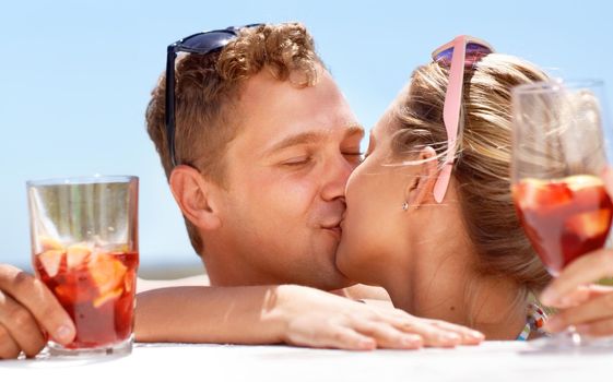 A young couple kissing passionately in the hot summer sun.