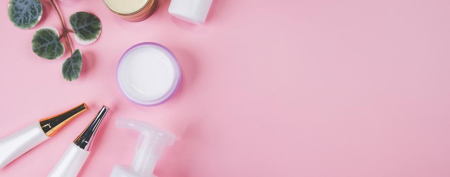 Mockup cosmetic bottle with cream or lotion and leaf isolated on pink background, mock up package for advertising, skincare or cosmetology, top view, flat lay, skin care and treatment with product.