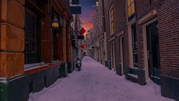 Snowy Red LIght District in winter in Amsterdam the Netherlands at sunset