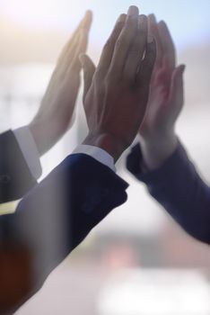 Cropped shot of a group of businessmen giving each other a high five.