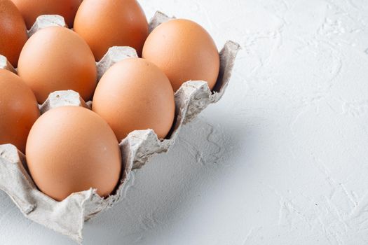 Fresh eggs on paper egg box set, on white background , with space for text copyspace
