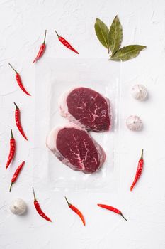 Packed pieces beef meat set, on white stone table background, top view flat lay