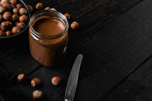 Sweet hazelnut spread set, on black wooden table background, with copy space for text