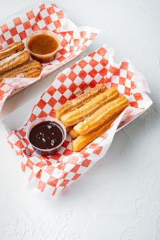 Spanish porras. Spanish food like spanish churros with chocolate, and caramel in paper tray, on white background