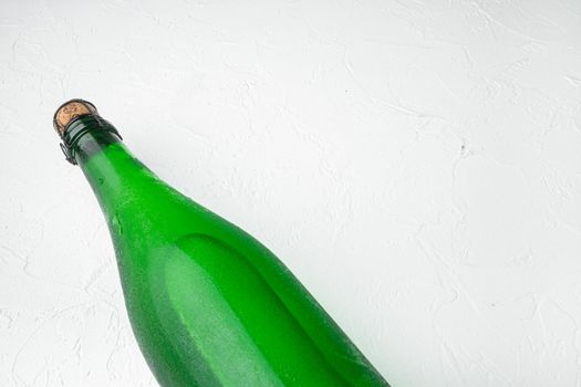 Bottle of sparkling wine set, on white stone table background, with copy space for text