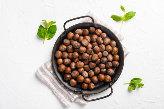 Hazelnuts brown wooden shell set, on white stone table background, top view flat lay