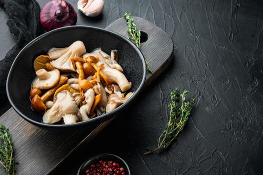 Marinated mushrooms set, on black background , with space for text copyspace