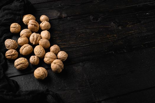 Walnuts with shells set, on black wooden table background, with copy space for text