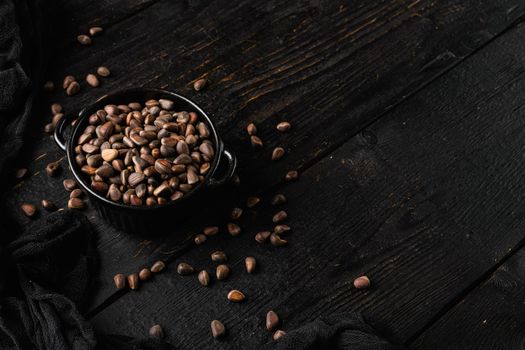 Pine nuts set, on black wooden table background, with copy space for text