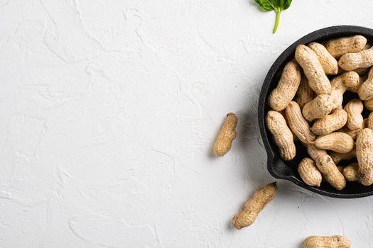 Peanuts serving to make oil, peanut butter set, on white stone table background, top view flat lay, with copy space for text