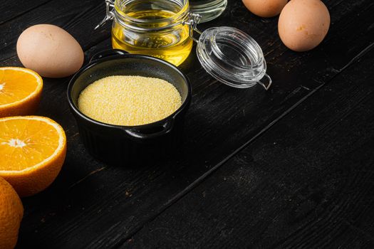 Polenta cake ingredients, with eggs and honey set, on black wooden table background, with copy space for text