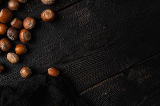 Hazelnut nut health organic brown filbert set, on black wooden table background, top view flat lay, with copy space for text