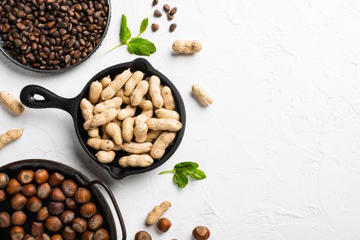 Organic peanuts in shell set, on white stone table background, top view flat lay, with copy space for text