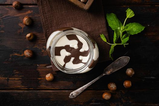 Chocolate spread jar set, on old dark wooden table background, top view flat lay