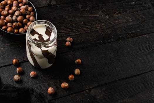 Sweet hazelnut spread set, on black wooden table background, with copy space for text