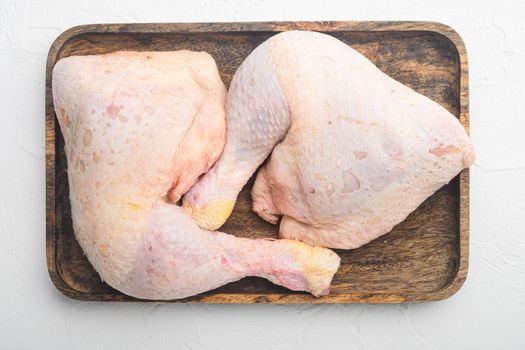Chicken brow and drumstick with skin set, on wooden tray, on white stone background, top view flat lay