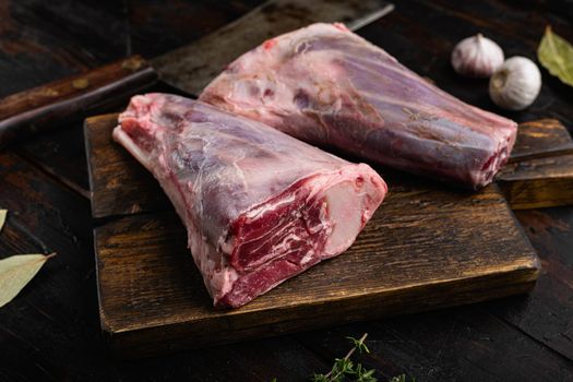 Raw lamb shanks with ingredients set, on old dark wooden table background