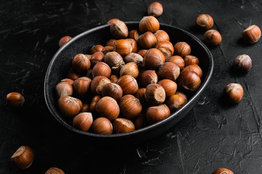 Organic Hazelnut whole nuts set, on black dark stone table background