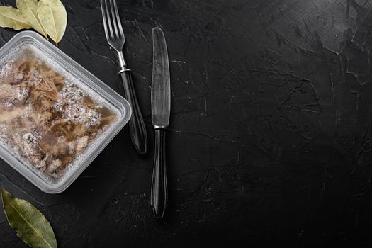 Jellied meat set, on black dark stone table background, top view flat lay, with copy space for text