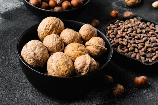 Walnut whole nut set, on black dark stone table background