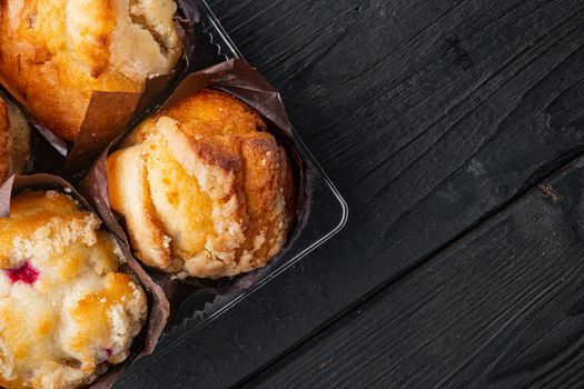 Delicious tasty muffin, on black wooden table background, top view flat lay with copy space for text