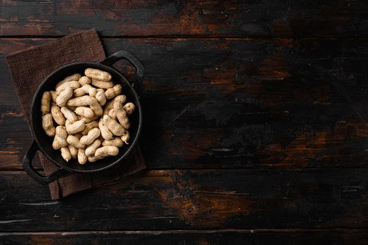 Dried peanuts. Tasty groundnuts set, on old dark wooden table background, top view flat lay, with copy space for text
