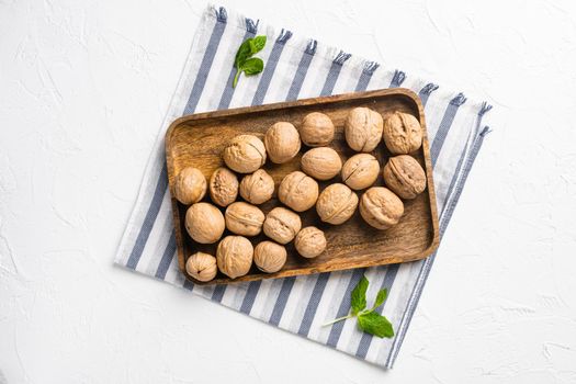 Walnut whole nut set, on white stone table background, top view flat lay