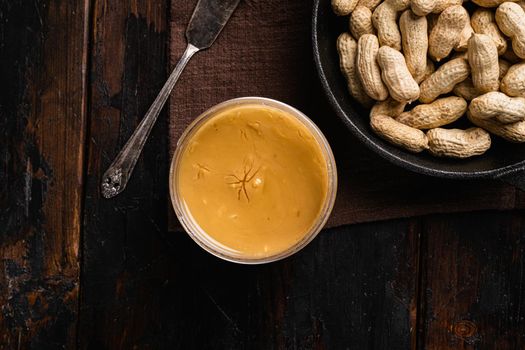 Peanut butter set, on old dark wooden table background, top view flat lay, with copy space for text