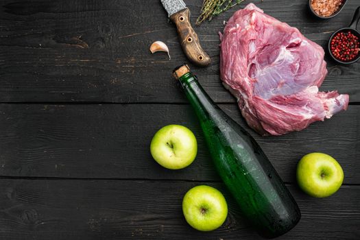 Raw pork cutlet with oil and spices for grill or cooking set, with apple dry cider, on black wooden table background, top view flat lay, with copy space for text