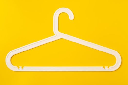 Hanger on colored paper background. Minimalistic fashion concept. Top view